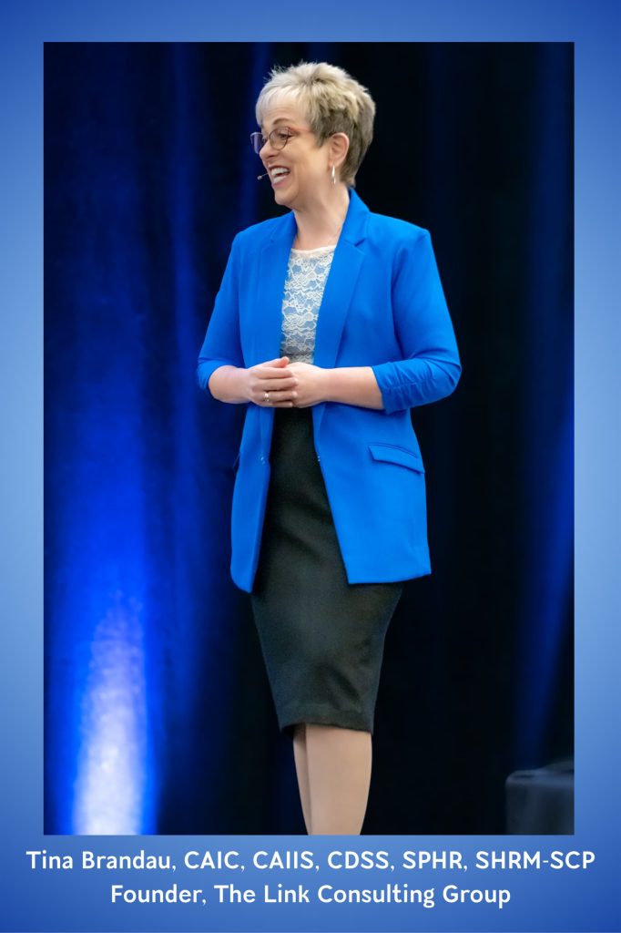 Image of Time Brandau on Stage Speaking in a Blue blazer and black shirt with a countryman microphone - Tina-Brandau-CAIC-CAIIS-CDSS-SPHR-SHRM-SCP-Founder-The-Link-Consulting-Group