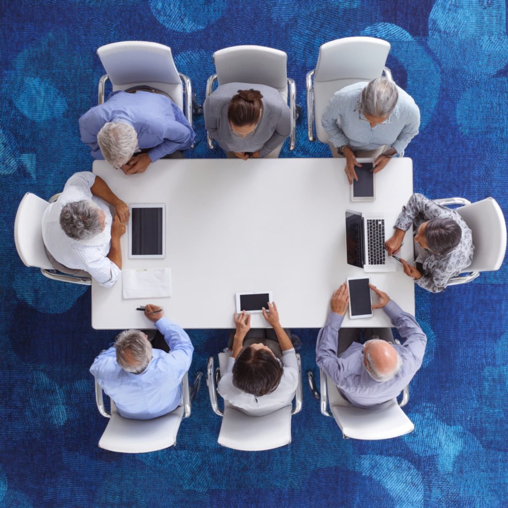 Image of team reviewing AI strategy report around conference table